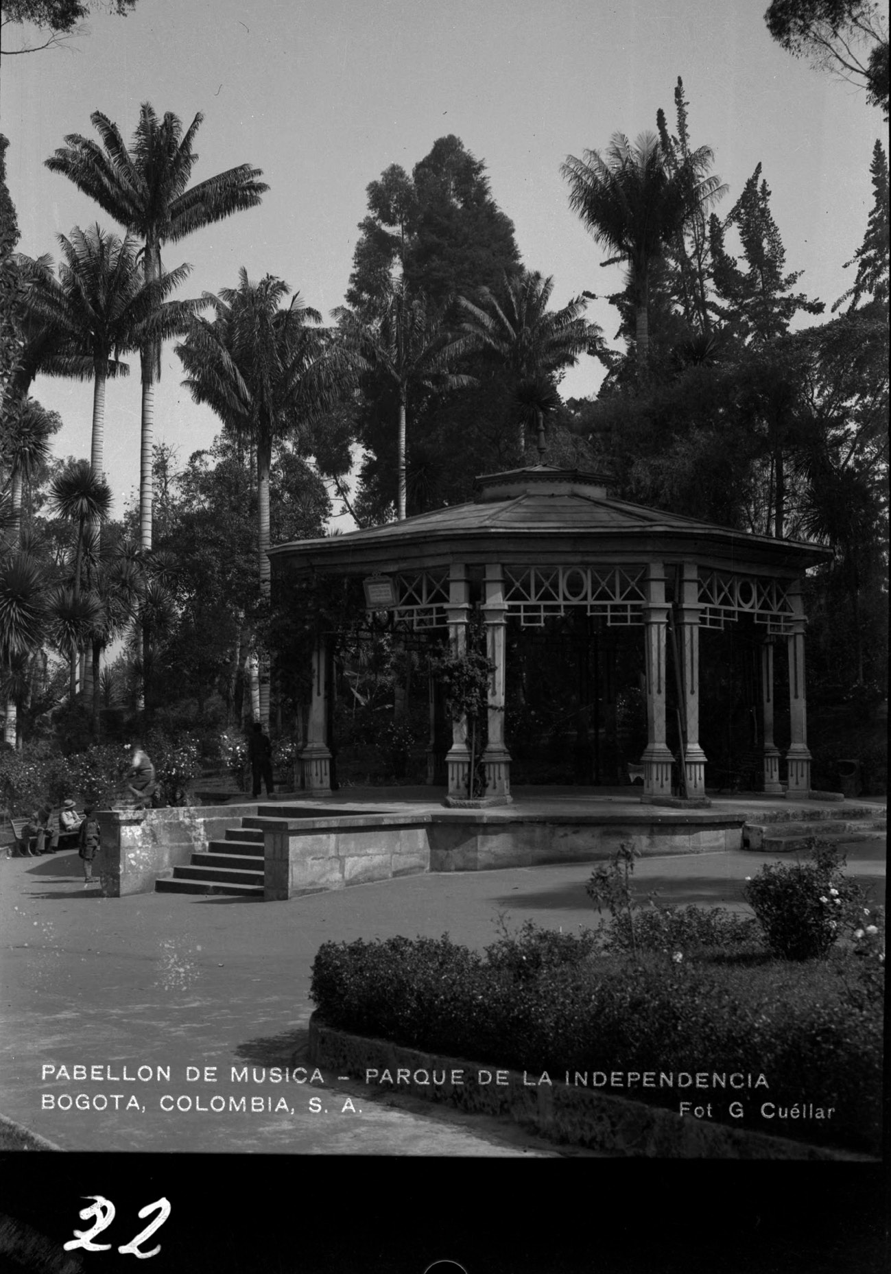 An antique photo of a gazebo surrounded by palm trees in a park.