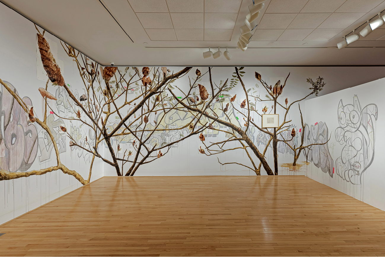 Five monitors showing natural materials hang at different heights along a white wall.