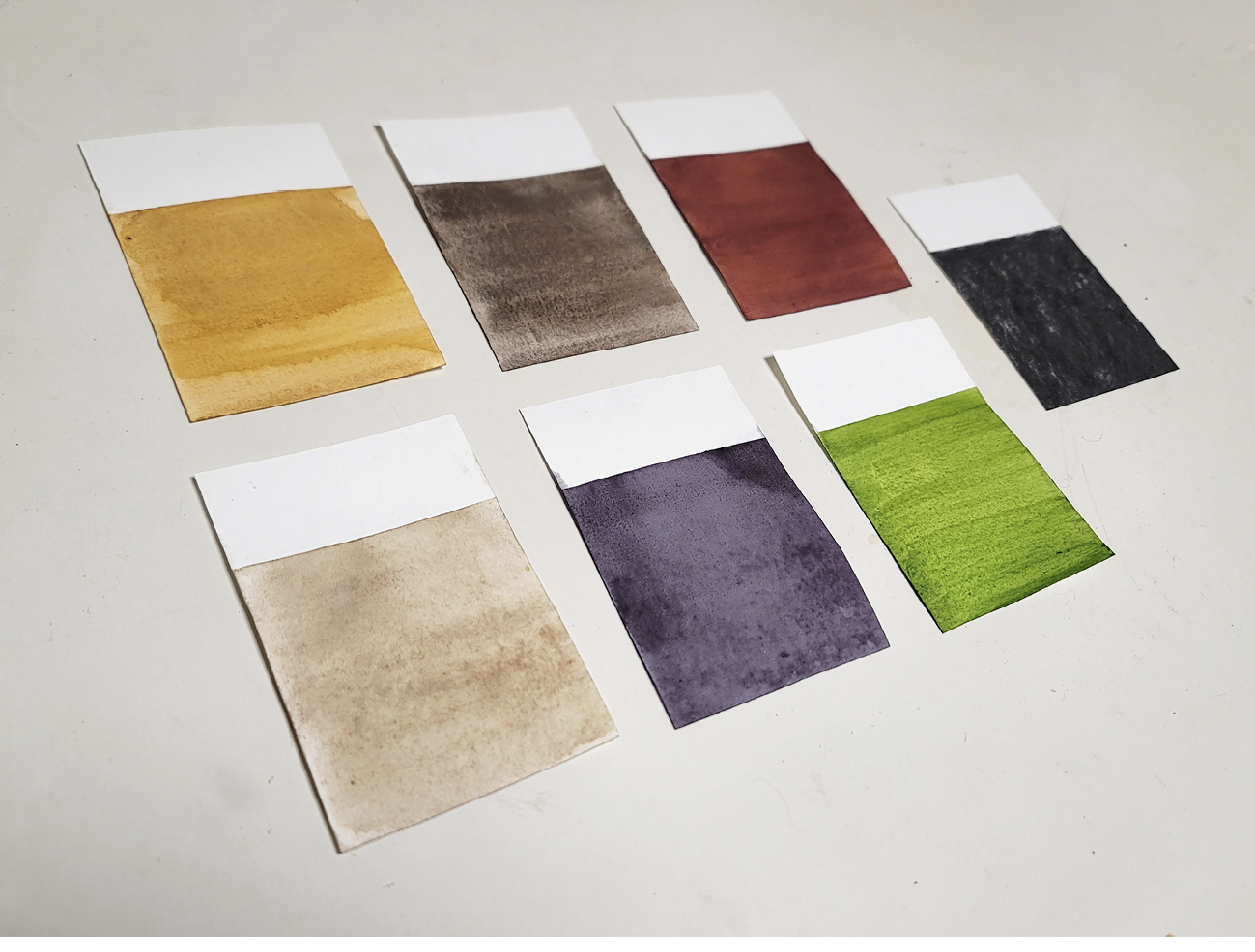 Seven colour swatches appear in two horizontal rows on a white surface.