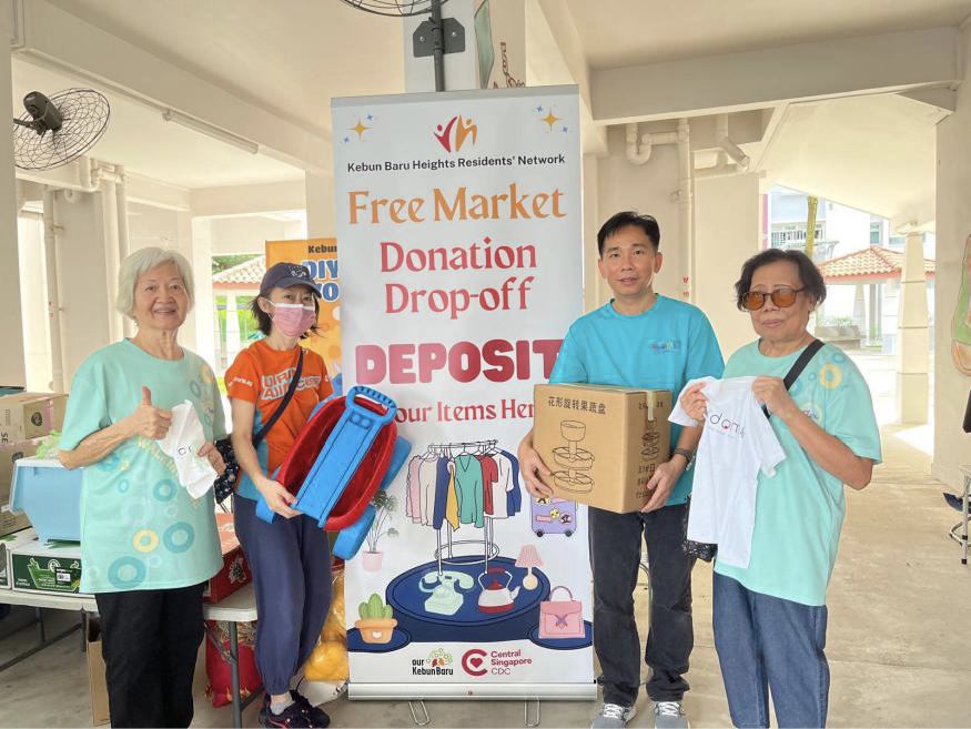 Group of people beside a sign for free market donation  drop-off