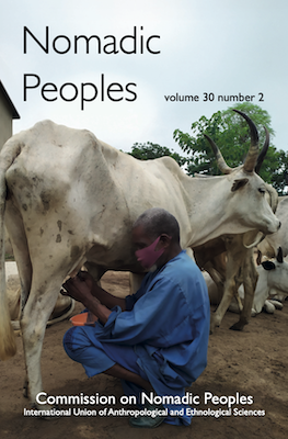 Journal cover image showing a man in a face mask milking a cow.